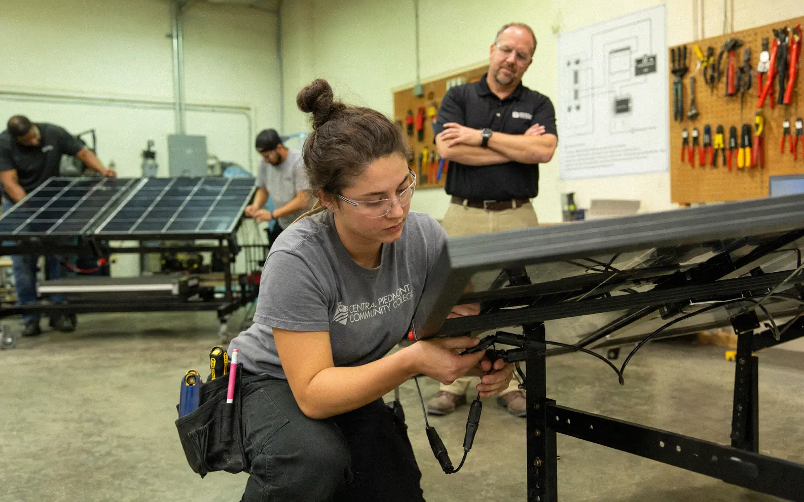 Student practicing solar panel wiring during a hands-on training course