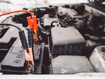 Solar jump starter charging a car battery outdoors