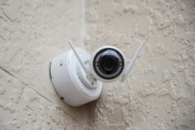 Solar-powered security camera mounted on a house exterior