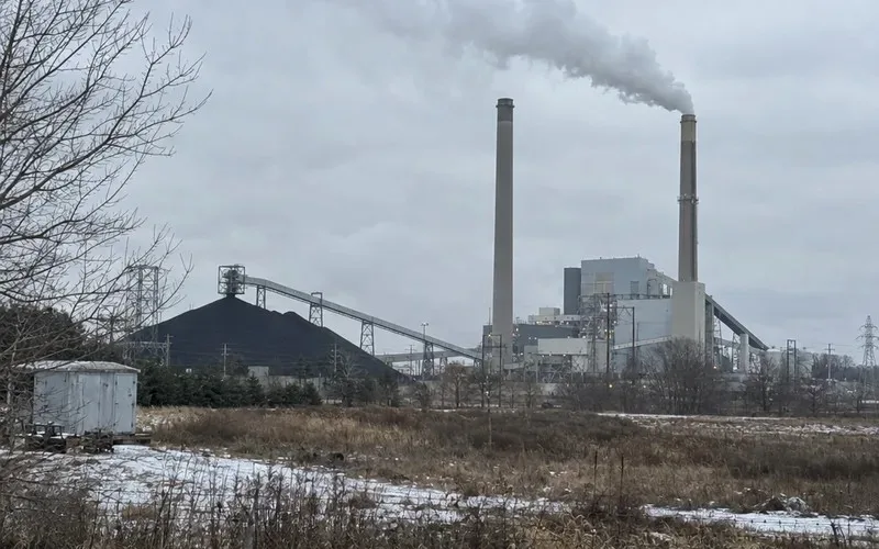Coal-fired power plant with smokestacks and a coal pile