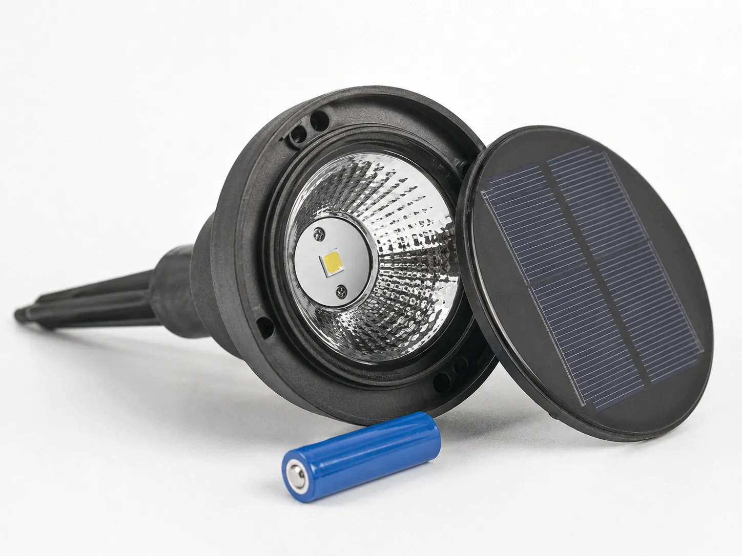 Disassembled solar garden light on a white surface showing the detached solar panel, cylindrical rechargeable battery, and small LED chip inside the fixture head