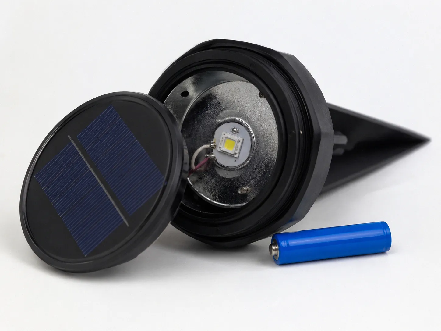 Solar pathway light in sharp focus during a heavy rainstorm at night with water droplets streaming down the black housing and solar panel