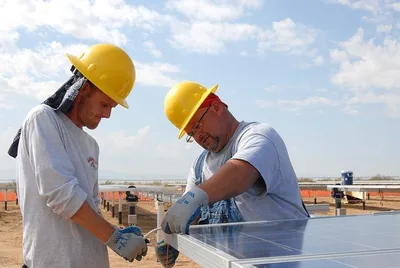 Solar installer securing panels on a rooftop