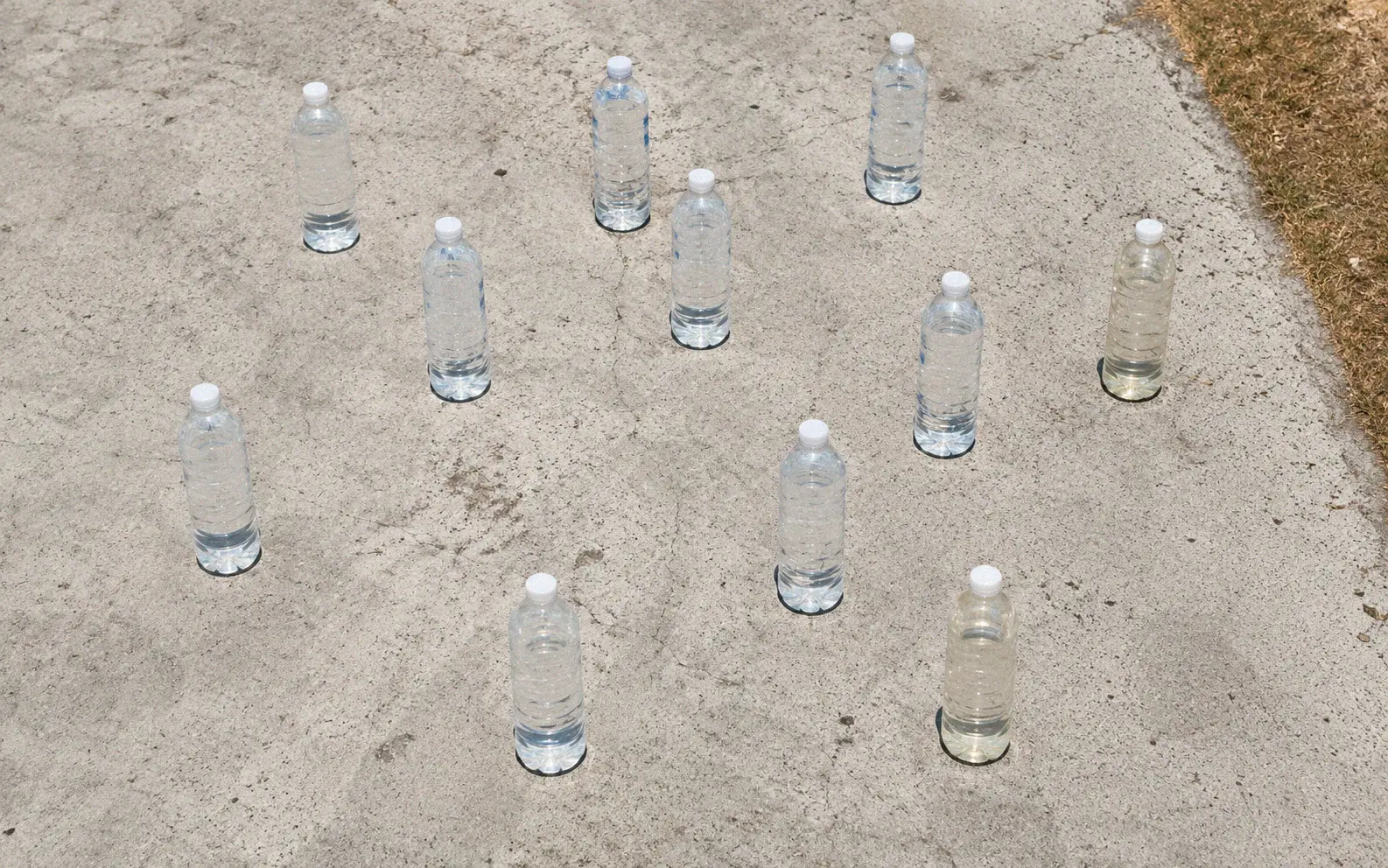 Water bottles in various stages of solar treatment under a clear midday sky