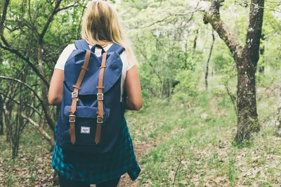 Solar backpack with panel charging a phone while hiking