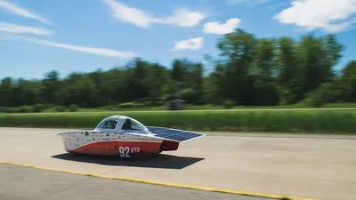 Solar-powered car driving on a sun-lit highway